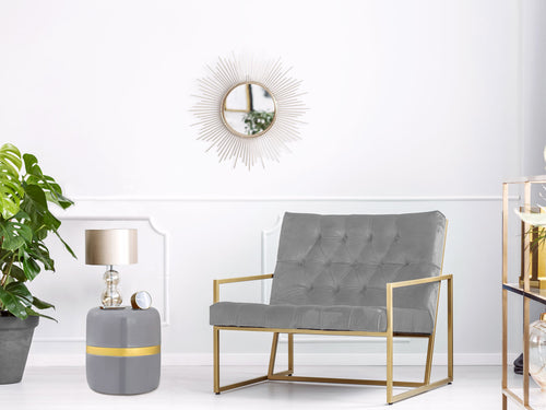 Wohnraum mit Beistelltisch Beverley in Grau und Gold neben einem grauen Sessel und einer Tischlampe